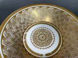 a close up of a bowl with a gold design on it