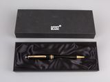 a black and gold pen in a black box on a white surface
