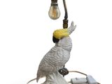 a white bird that is sitting on top of a lamp