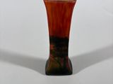 a small vase that is sitting on a white surface