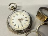 a silver pocket watch with roman numerals on it