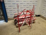 a pile of red and white skis sitting on a pallet in front of a wall