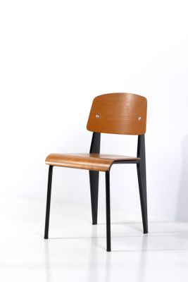 une chaise en bois avec des pieds noirs et une assise en bois