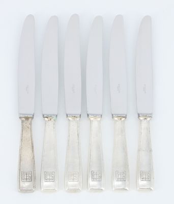 un ensemble composé de cinq couteaux en métal argenté et d'un porte-couteaux