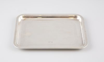 un plateau en argent posé sur une table blanche, sur fond blanc