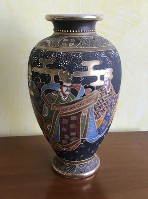 un vase avec un tableau posé sur une table