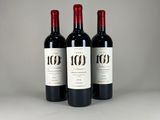 three bottles of red wine sitting on top of a table