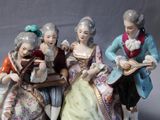 three figurines of people that are sitting on a table