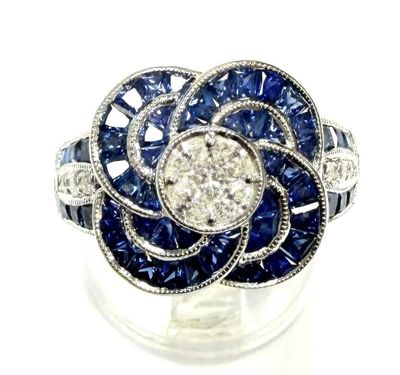 an image of a diamond and sapphire flower ring on a clear surface