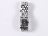 a close up of a watch on a white surface with a black and white zigzag pattern