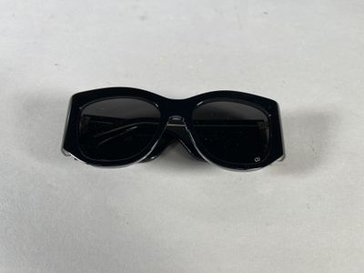 a close up of a pair of black sunglasses on a white surface