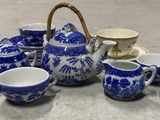 un service à thé bleu et blanc comprenant des tasses et un panier