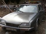 a silver car that is parked in a junkyard