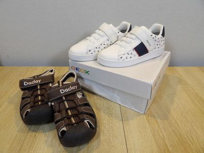 baby boy ' s white and brown shoes and a box on a wooden table