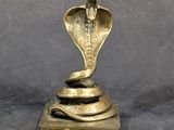 statue of a cobra on a base with a snake wrapped around it