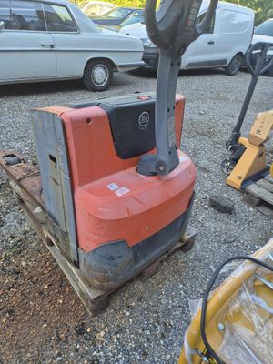 a forklift sitting on top of a pallet in a parking lot