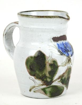 a white vase with a blue flower painted on it