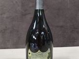 une vieille bouteille de champagne posée sur une table en bois, sur fond marron