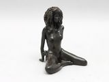 statue of a woman sitting on the ground with her legs crossed