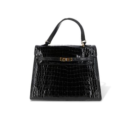 un sac à main en cuir de crocodile noir sur fond blanc