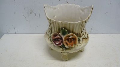 un vase blanc avec des fleurs posé sur une table
