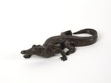 un petit alligator allongé sur une surface blanche