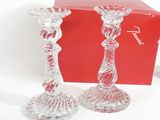 pair of clear glass candlesticks in front of a red box