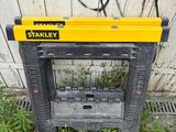 a yellow and black tool stand in front of a wall with graffiti