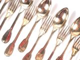 a lot of silver spoons and forks on a white surface