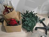 un sapin de Noël dans une boîte, posé par terre à côté d'une chaise de bureau
