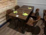 une table en bois avec quatre chaises et un verre posé dessus
