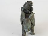 a statue of a bear holding a baby elephant on its back
