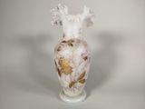 un vase blanc orné d'un motif rose et doré