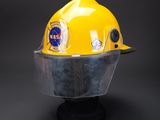 a close up of a yellow hard hat with a clear visor