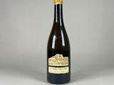 une bouteille de vin posée sur une table blanche