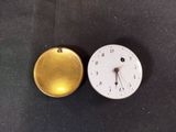 two clocks that are sitting on a black surface