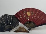 deux éventails rouges et noirs ornés de motifs dorés