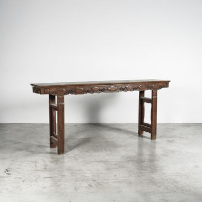 une vieille table en bois posée sur un sol en béton