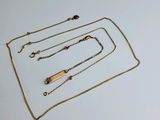 une collection de colliers et de bracelets en or posés sur un fond blanc