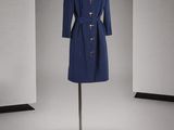 un manteau bleu posé sur un pied de mannequin dans une pièce