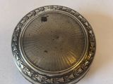 an antique silver pocket watch on a white surface