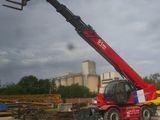 a crane that is sitting on the ground in front of a building