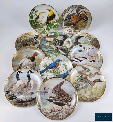 une multitude d'assiettes ornées d'oiseaux posées sur une table