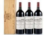 three bottles of red wine and a wooden box on a white surface
