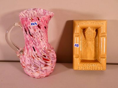 a pink glass pitcher next to a yellow soap dish