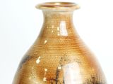 a brown and black vase sitting on a white surface