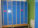 blue lockers are lined up in a row in a green room