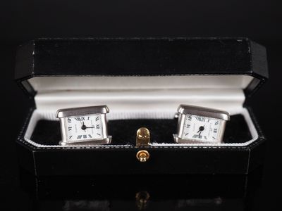 pair of silver cuff watches in a black box on a black surface