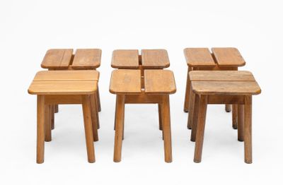four small wooden stools sitting next to each other on a white surface