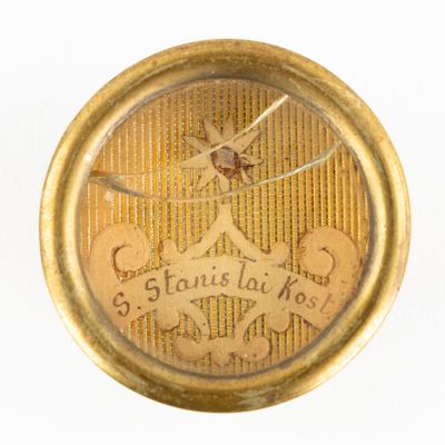 a close up of a gold pocket watch on a white surface